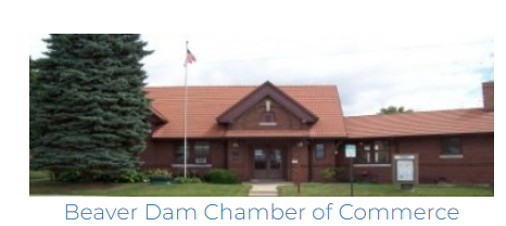 The Beaver Dam Chamber of Commerce building with a red tile roof and an American flag out front, serving as a wedding venue and reception hall in Beaver Dam, WI.